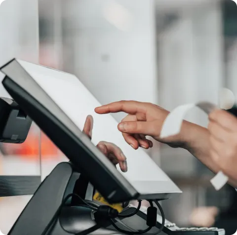 Person using POS terminal touchscreen in restaurant